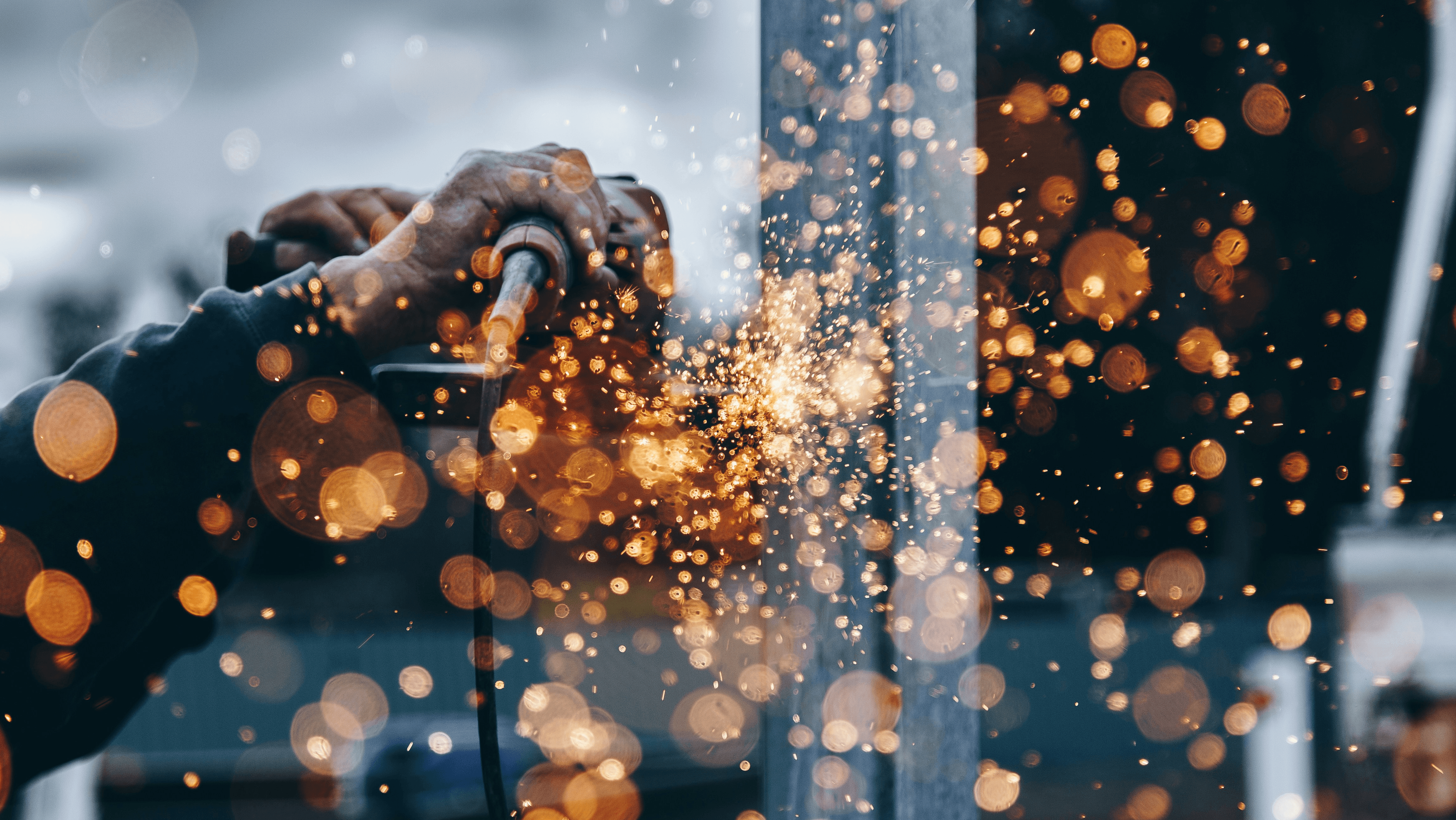 Technician grinding steel with sparks in the Oilogix shop